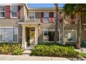 Inviting townhome with red shutters, lush landscaping, and a decorative front door at 12443 Country White Cir, Tampa, FL 33635