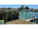 Scenic view of waterfront property featuring a private boat dock and lush greenery at 12478 Capri Circle N # 2, Treasure Island, FL 33706