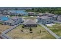 Aerial view of home featuring a spacious backyard, adjacent pond, and lush surrounding neighborhood at 13506 Wild Ginger St, Riverview, FL 33579