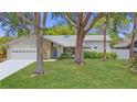 Landscaped front yard, a stone facade, and a well-maintained lawn provide excellent curb appeal at 13891 Feather Sound Dr, Clearwater, FL 33762