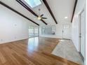 Bright living room boasts hardwood floors, vaulted ceiling with wooden beams, and sliding doors to the backyard at 13891 Feather Sound Dr, Clearwater, FL 33762