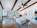 Sunlit living room with high ceilings, exposed beams, and cozy seating arrangements at 13891 Feather Sound Dr, Clearwater, FL 33762