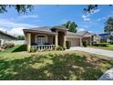 Charming single-story home with a well-manicured lawn, inviting front porch, and two-car garage at 1406 Bloomingdale Trails Blvd, Brandon, FL 33511