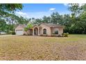 Single-story home with two car garage on a lot with mature trees and landscaping at 15703 Walden Ave, Tampa, FL 33618