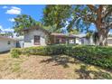 Single-story home showing the mature bushes in the front yard at 1610 15Th N St, St Petersburg, FL 33704