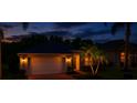 Charming single-story home with a two-car garage, red brick driveway and manicured lawn at night at 16113 Rambling Rd, Odessa, FL 33556