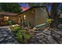 Landscaped area with plants, lighting, rocks and decorative pots adds curb appeal to the front exterior at 1647 Hamilton Ct, Dunedin, FL 34698