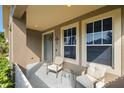 Cozy front porch with seating area, decorative wreath, and two large windows at 19528 Sunset Bay Dr, Land O Lakes, FL 34638