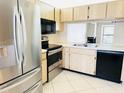 Kitchen with stainless steel appliances, wood cabinets, and views into the living room at 2024 Blue Hawk Ct # 1822, Clearwater, FL 33762