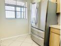 Kitchen featuring stainless steel refrigerator, window, and light wood cabinets at 2024 Blue Hawk Ct # 1822, Clearwater, FL 33762