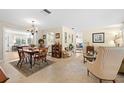 Open dining room featuring hardwood floors, chandelier, and a view into the living area at 2060 Attache Ct, Clearwater, FL 33764