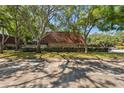 Exterior view of the condo building, surrounded by mature trees and landscaping, with dedicated parking spaces at 2722 11Th Ct # 50A, Palm Harbor, FL 34684