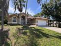 Inviting single-story home with lush landscaping, a double-door entrance, and an attached two-car garage at 2752 Cypress Dr, Clearwater, FL 33763