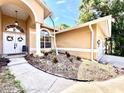 Close-up of home's entrance featuring columns, arched windows, double doors, and an attractive landscaped bed at 2752 Cypress Dr, Clearwater, FL 33763
