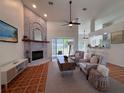 Open-concept living room featuring a brick fireplace, high ceilings, ceiling fans, and tile flooring at 2752 Cypress Dr, Clearwater, FL 33763