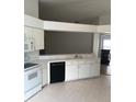Bright kitchen features white cabinets, laminate countertops, and black appliances at 3314 Pine Top Dr, Valrico, FL 33594