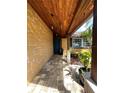 Inviting front porch with stone accent wall, brick paver walkway, and a rich wood plank ceiling at 3532 Overland Dr, Holiday, FL 34691