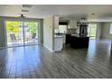 Open-concept living space with gray tile flooring and sliding glass doors with water views at 3532 Overland Dr, Holiday, FL 34691