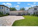 Charming home features a manicured lawn, a brick driveway, and lush landscaping with ample curb appeal at 3906 W De Leon St, Tampa, FL 33609