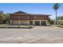 Two-story home with brown wood paneling, two-car garage, and well-maintained lawn at 588 Bayview Dr, Longboat Key, FL 34228
