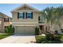 Inviting two-story home with a neutral exterior, large garage door, and manicured front lawn at 5928 81St N Ave, Pinellas Park, FL 33781