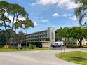 Exterior view of the condo featuring mature landscaping and designated parking at 6070 80Th N St # 308, St Petersburg, FL 33709