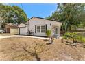 Well-maintained single Gathering home with a white exterior, green lawn, garage, and classic architectural design at 6204 Nebraska Ave, New Port Richey, FL 34653