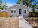 Inviting one-story house with a blue door, complementing the neutral exterior and walkway at 8114 N 11Th St, Tampa, FL 33604
