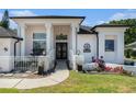 Elegant front entrance of a home with pillars, a gated courtyard, and beautiful landscaping at 8406 Glengarry Pl, Trinity, FL 34655