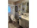 Bathroom featuring a toilet, sink, and decorative wallpaper at 9481 Patrick St, Brooksville, FL 34601