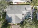 Aerial view showcasing a home's roof, screened-in pool, and surrounding trees and landscaping at 1069 Captains Way, Tarpon Springs, FL 34689