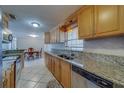 Bright kitchen features stainless steel appliances, wood cabinets, tile floors and granite countertops at 11546 Leisure W Ln, Largo, FL 33773