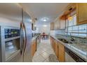 This kitchen offers stainless steel appliances, tile flooring, and wooden cabinets and an adjacent dining area at 11546 Leisure W Ln, Largo, FL 33773