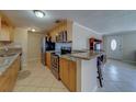 Well-lit kitchen features stainless steel appliances, tile flooring, and wooden cabinetry at 11546 Leisure W Ln, Largo, FL 33773