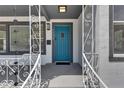 A welcoming front porch with decorative railings leads to a vibrant blue front door at 1208 E 18Th Ave, Tampa, FL 33605