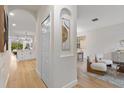 Open hallway with arched doorways leading to a bright living room and modern kitchen at 12531 Blazing Star Dr, Tampa, FL 33626