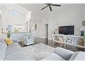 Bright living room with dark hardwood floors, a modern grey sofa, and a decorative area rug at 13135 Plantation Ter, Seminole, FL 33776