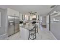Bright kitchen with white cabinets, stainless steel appliances, and a center island with seating at 13208 Sydney Rd, Dover, FL 33527