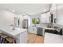 Stylish kitchen boasts white cabinets, stainless steel appliances, a sleek countertop, and hardwood floors at 1401 49Th N St, St Petersburg, FL 33710