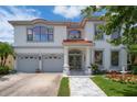 Elegant two-story home featuring a red tile roof, well-manicured lawn, and a welcoming entrance at 15630 N Himes Ave, Tampa, FL 33618