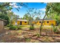 A spacious backyard of a yellow house, perfect for outdoor activities and relaxation at 1665 Laura St, Clearwater, FL 33755