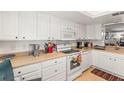 Well-lit kitchen featuring white cabinets, appliances, and ample counter space at 2212 Lark W Cir # E, Palm Harbor, FL 34684