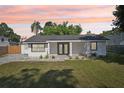 Charming single-story home with a well-maintained lawn and minimalist landscaping, framed by a colorful sunset at 2288 Cheryl Rd, Largo, FL 33771