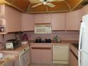 Corner kitchen with pink cabinetry, white appliances, ceiling fan and tile flooring at 2618 Cove Cay Dr # 403, Clearwater, FL 33760