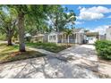Quaint single-story house with a charming front porch and spacious driveway with a covered parking area at 3709 W Santiago St, Tampa, FL 33629