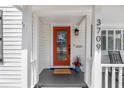 Charming front entrance with a vibrant orange door, decorative plants, and a welcoming 'welcome' mat at 3709 W Santiago St, Tampa, FL 33629