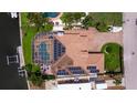Bird's eye view of waterfront home with a screened pool, dock, boat lift, and solar panels at 3931 Pompano Se Dr, St Petersburg, FL 33705