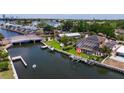 Waterfront property featuring a private dock, boat lift, screened pool, and solar panels on the roof at 3931 Pompano Se Dr, St Petersburg, FL 33705