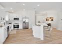Modern kitchen boasts white cabinets, stainless steel appliances, and a center island with bar seating at 4105 Waterville Ave, Wesley Chapel, FL 33543