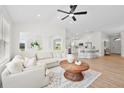 Bright living room with white walls, modern fan, and cozy sectional couch with a clear view to the kitchen at 4105 Waterville Ave, Wesley Chapel, FL 33543
